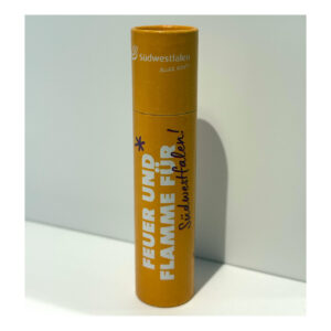 Das Bild zeigt Streichhölzer in einer runden Verpackung in gelb-orange stehend mit der Aufschrift "Feuer und Flamme für Südwestfalen!"